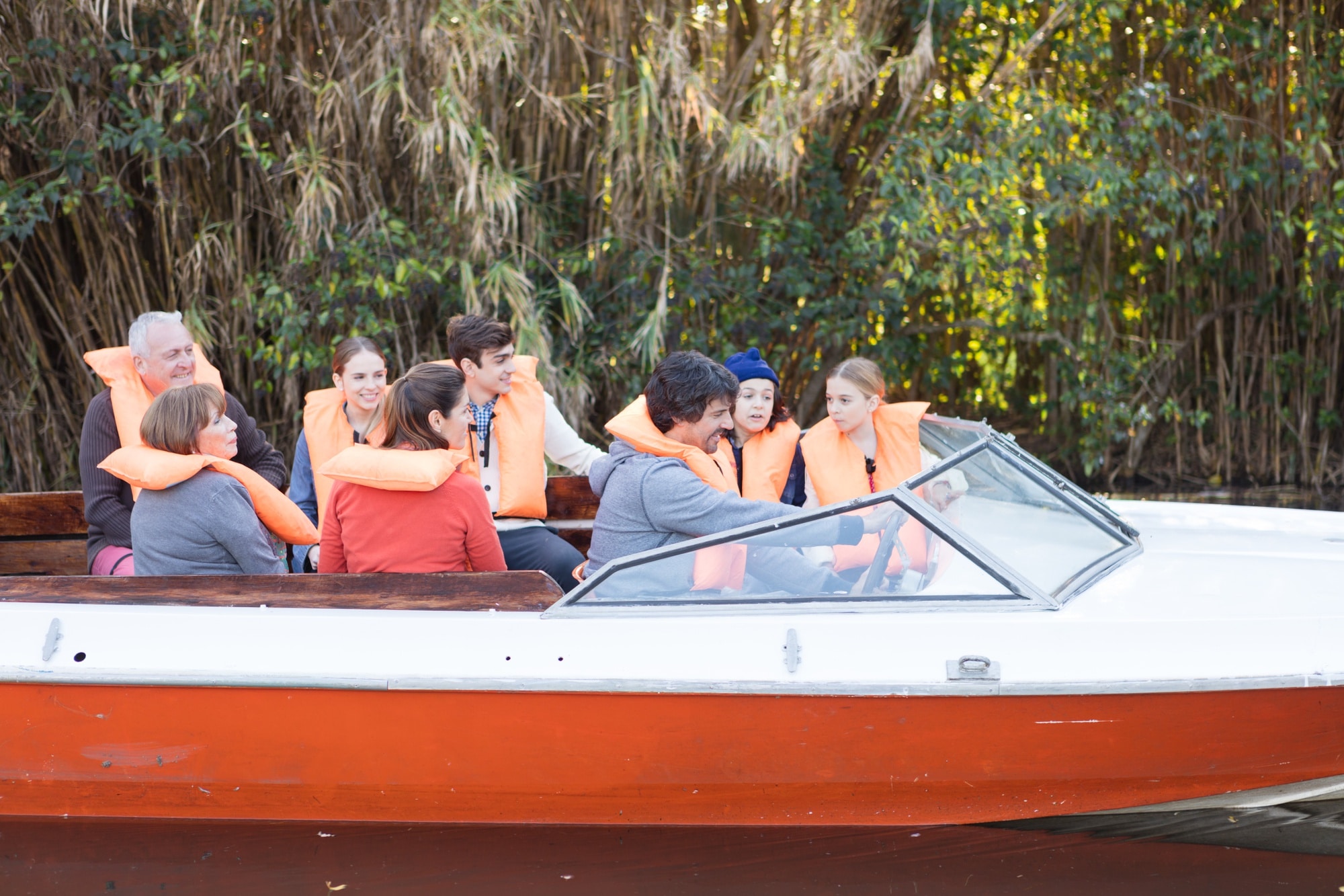 A group of people wearing life-jackets on a boat 