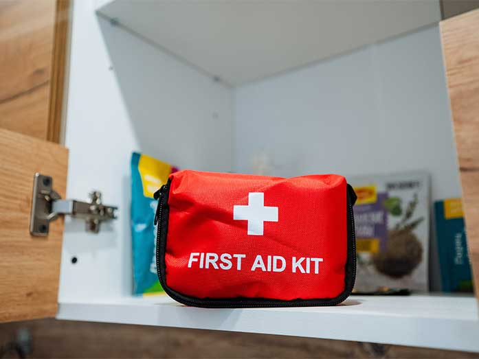 A fully equipped first aid kit, containing essential supplies for treating injuries and illnesses, is stored in a designated cabinet for easy access during emergencies or medical situations